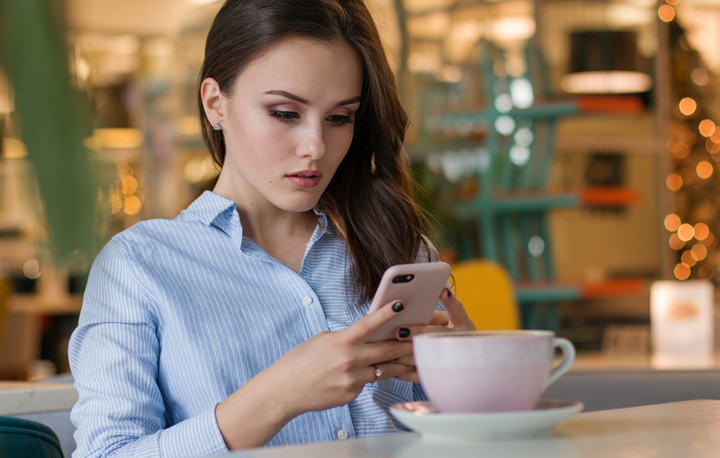 Woman at coffeeshop looking at phone