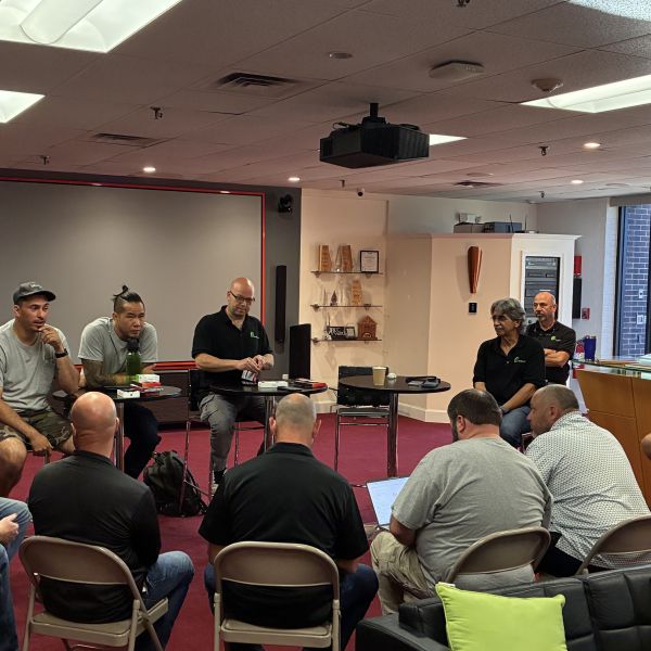 Four people standing together at an award ceremony, one holding an award, all smiling.