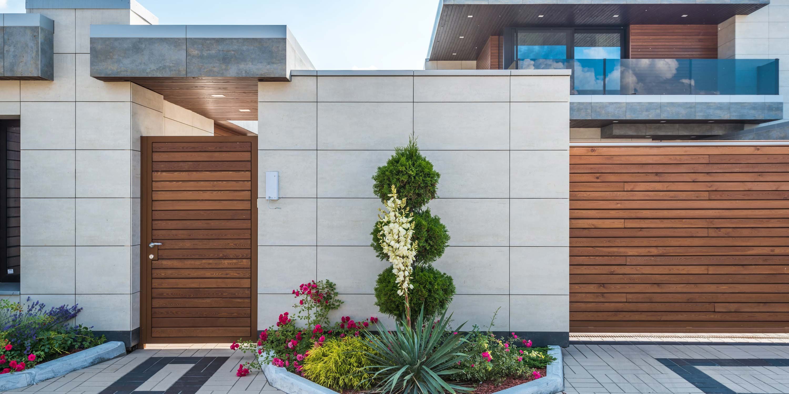 modern home with entry gates and travertine stone
